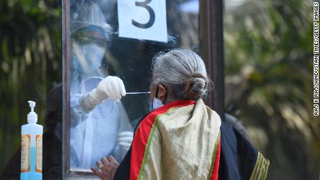 A medic collects a swab from a woman to test for Covid-19 on June 18 in New Delhi, India.   