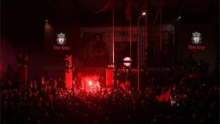 Fans celebrate Liverpool winning the Premier League title outside Anfield stadium