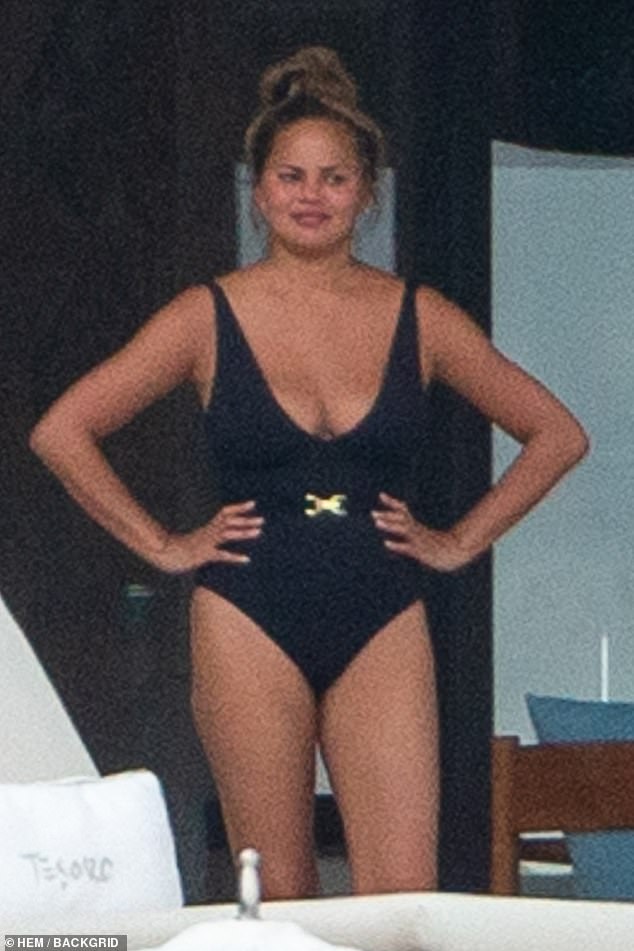 A lovely look: Chrissy Teigen was seen on the back patio of her villa in Puerto Vallarta, Mexico on Tuesday morning. The supermodel was in a flattering black one-piece swimsuit