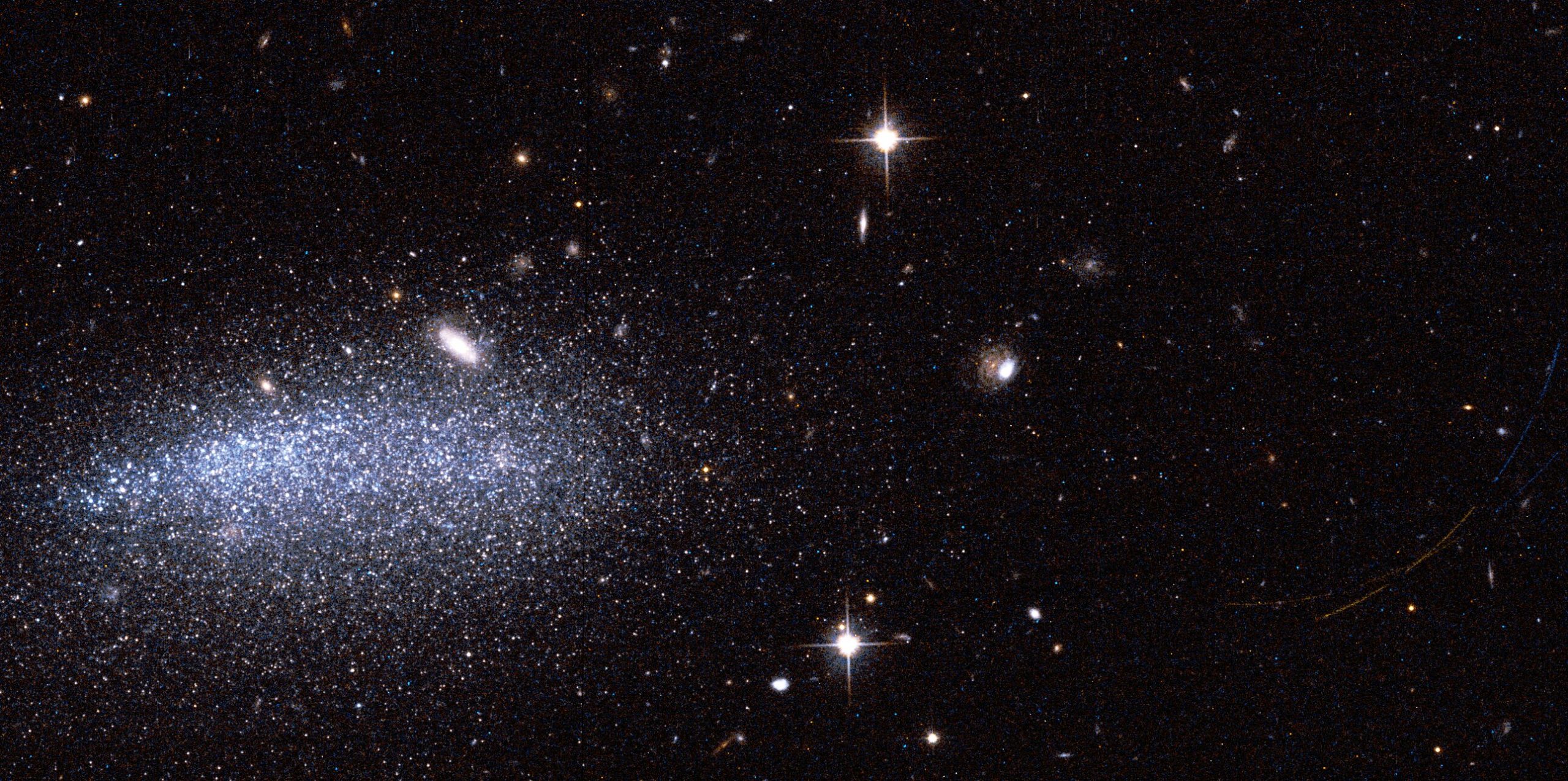 Hubble captures one galaxy, two asteroids