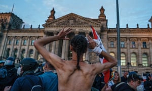 A demonstrator raises his arms as police start to detain right-wing protesters in front of the Reichstag building in Germany on Saturday.