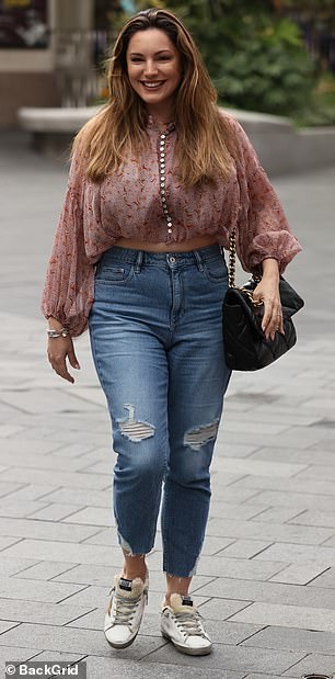 Cheerful: Kelly, 40, made a bright smile as she made her way inside the Leicester Square studio, wearing a baggy top and ripped jeans.