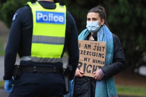 A woman holds a sign talking to police during a protest in Melbourne.