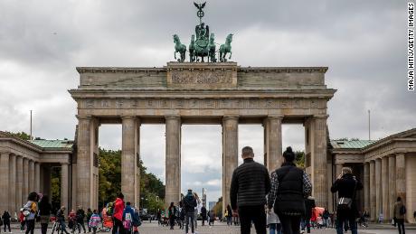 Tourists walk at the Brandenburg Gate in Berlin, Germany on October 12, where gatherings were limited to 10 people and a curfew was imposed at 11 pm in several regions.