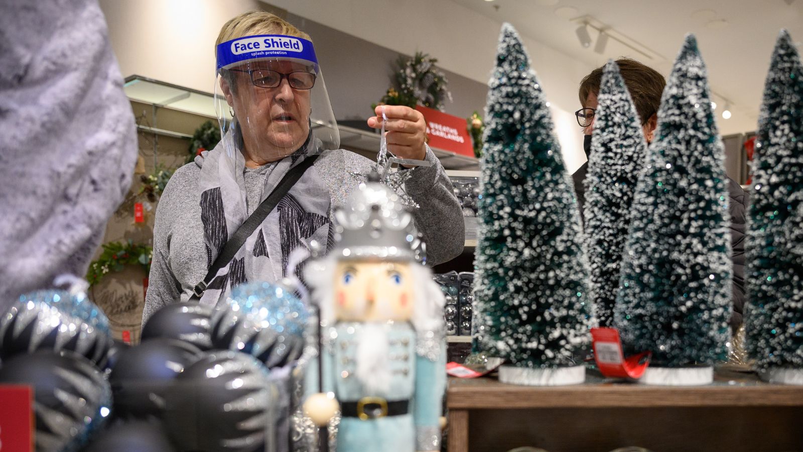 LONDON, ENGLAND - OCTOBER 20: A customer browses some of the festive items in the Christmas gift and decoration section in the branch of retailer Marks and Spencer at Westfield White City on October 20, 2020 in London, England. The high street store has announced that searches for Christmas-related items have tripled on previous years. The British Retail Consortium (BRC) has launched a new “Shop early, Start wrapping, Enjoy Christmas” national campaign, encouraging British consumers to start their festive shopping early. The aim is to both spread the amount of footfall in stores to aid social distancing, and to ensure that retail stores survive the Christmas period, despite COVID-19 preventative measures. (Photo by Leon Neal/Getty Images)