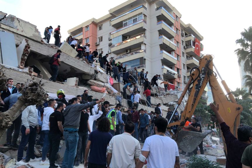 Rescuers and locals try to rescue residents trapped in the rubble of a collapsed building.