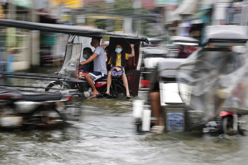 Residents in traffic during a flood in the Philippines.