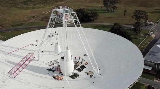 Work crews carry out important upgrades and repairs to the 70-meter (230-foot-wide) radio antenna at Deep Space Station 43 in Canberra, Australia.  In this section, one of the antenna's white feed cones (which houses parts of the antenna receivers) is driven by a lever.  (Credits: CSIRO)