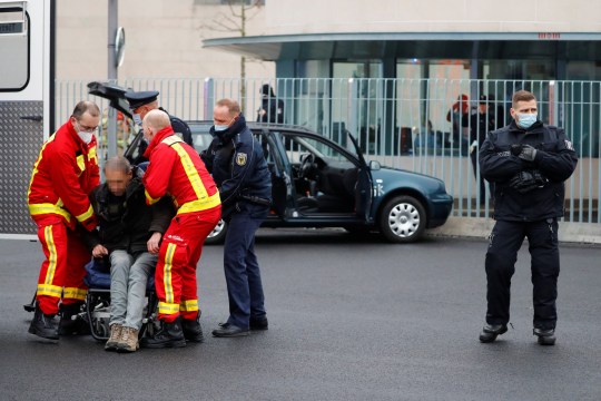 Firefighters bring in a man who collided with his car at the Chancellery's main gate in Berlin, German Chancellor Angela Merkel's office in Berlin, Germany, November 25, 2020. Reuters / Fabrizio Pinch