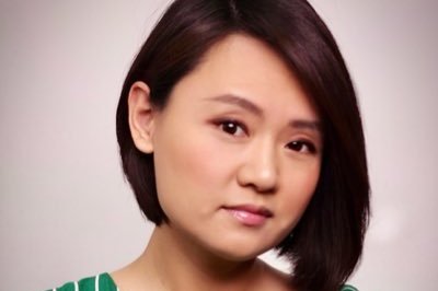 Young Chinese looking woman in green and white striped shirt. 