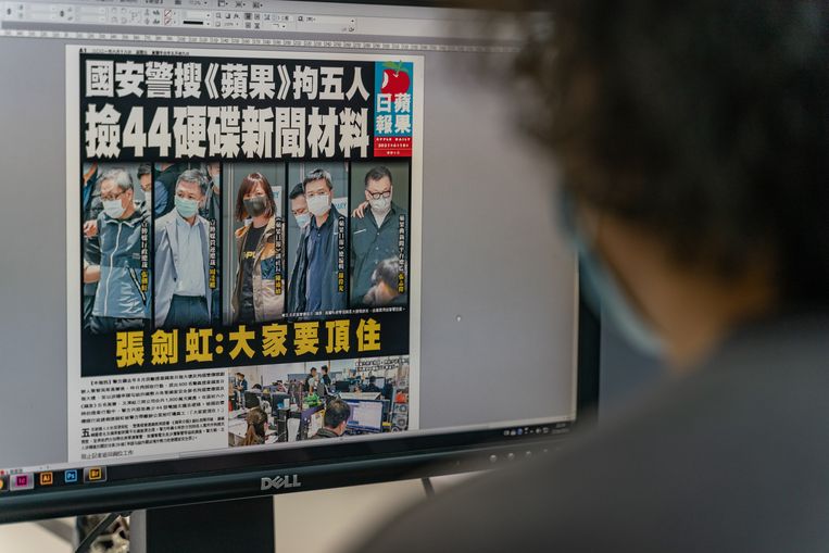 The editor of the Apple Daily with the front page of the Friday newspaper on his screen, which displays photos of the five arrested executives.  Image Getty Images
