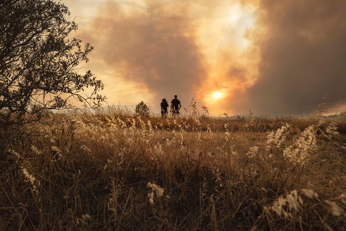Locals watch a forest fire in southern France from a distance.