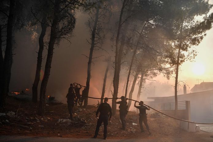 Police officers help firefighters put out a fire in Thracomakdones.