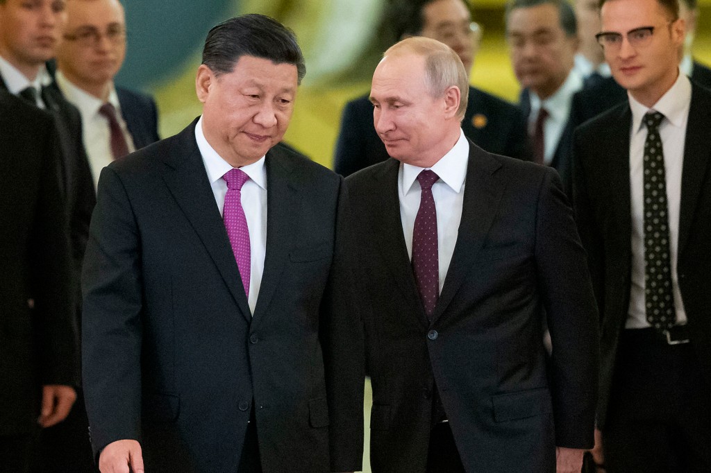 Vladimir Putin (right) told President Xi Jinping (left) that he plans to meet in February and attend the Olympics. 