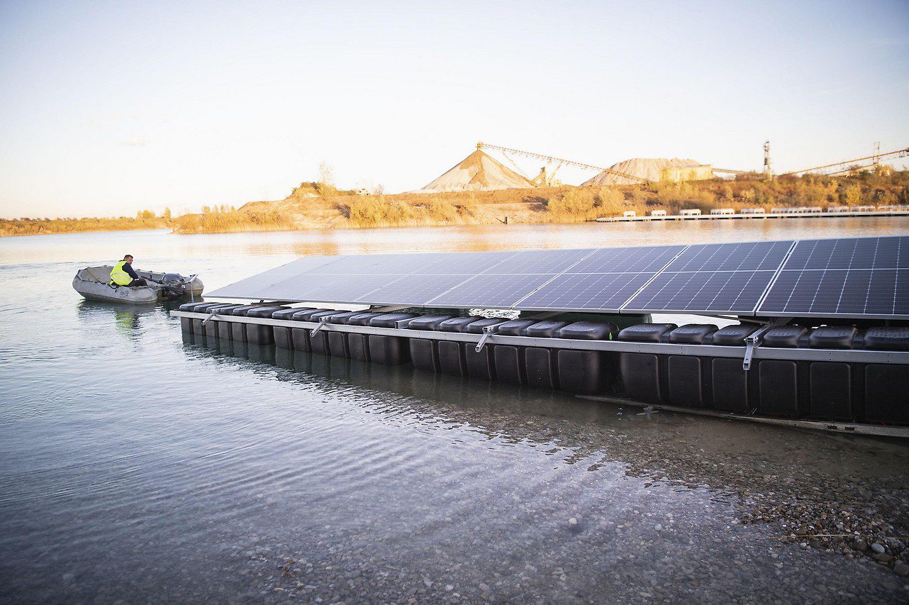 The boat pulls the photovoltaic system floating on the water